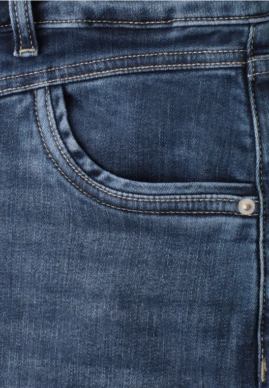 Close-up van een donkerblauwe spijkerbroek met zichtbare zak en stiksels.