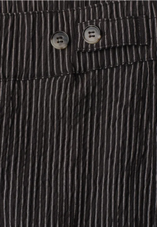 Nahaufnahme einer schwarz-weiß gestreiften Hose mit feinen vertikalen Streifen und zwei Knöpfen am Bund.