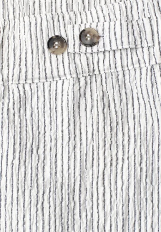 Nahansicht von weißer, gestreifter Stoffhose mit zwei Knöpfen und schmalen schwarzen Längsstreifen.