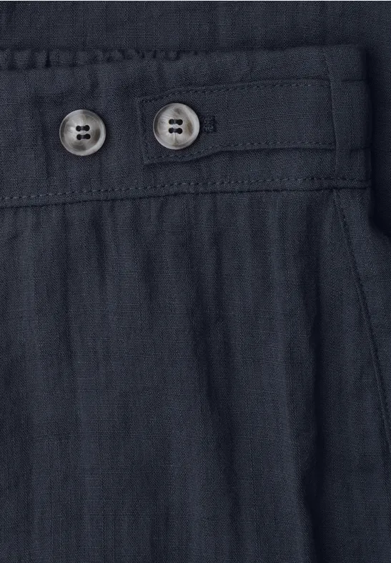 Detail einer schwarzen Leinenhose mit Tunnelzugbund und zwei Knöpfen.