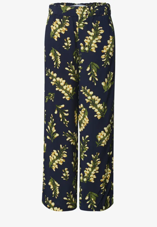 Donkerblauwe wijde broek met gele bloemen en groene bladeren.