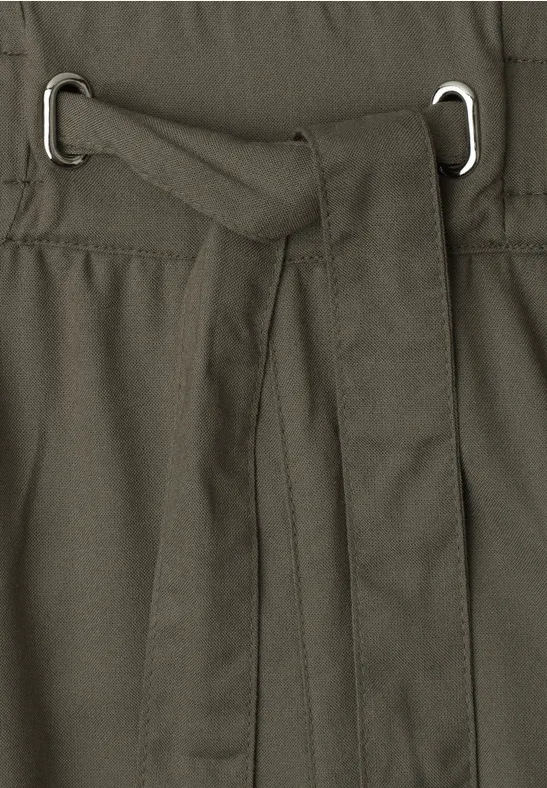 Close-up van een olijfgroene stoffen tailleband met een geknoopte stofriem door twee metalen D-ringen.