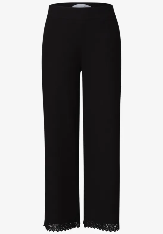 Schwarze Damenhose mit geradem Bein und filigranem Spitzensaum am Saum.
