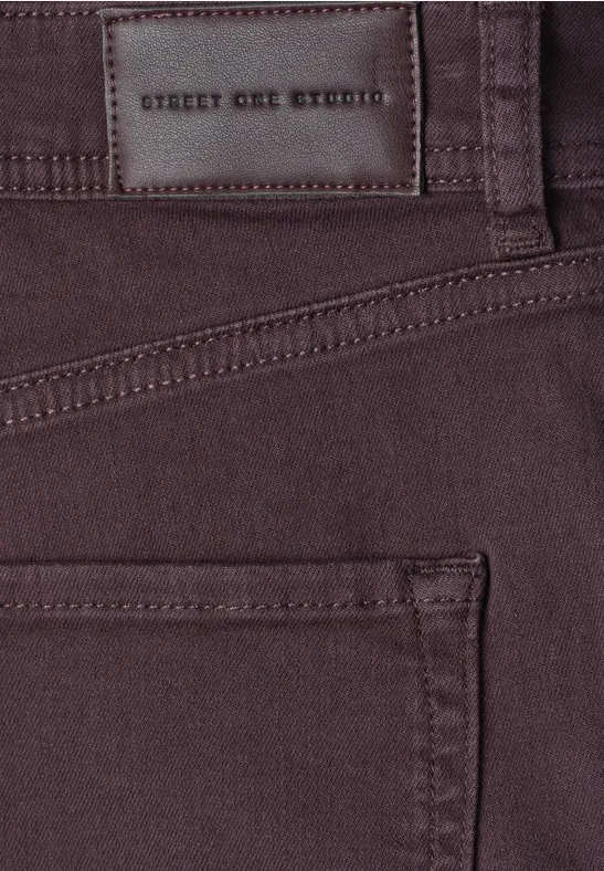 Nahaufnahme einer dunkelvioletten Hose mit braunem Lederetikett 'STREET ONE STUDIO' über der Gesäßtasche