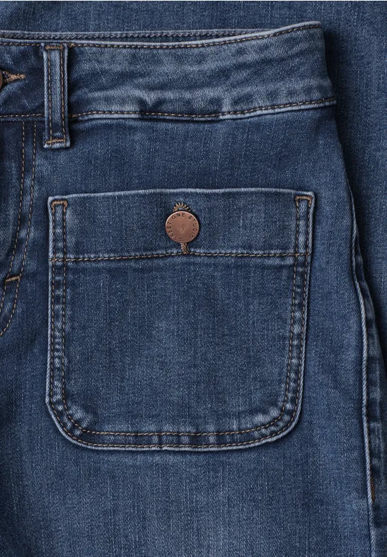 Nahaufnahme einer blauen Jeanshose mit aufgesetzter Tasche und Knopf.