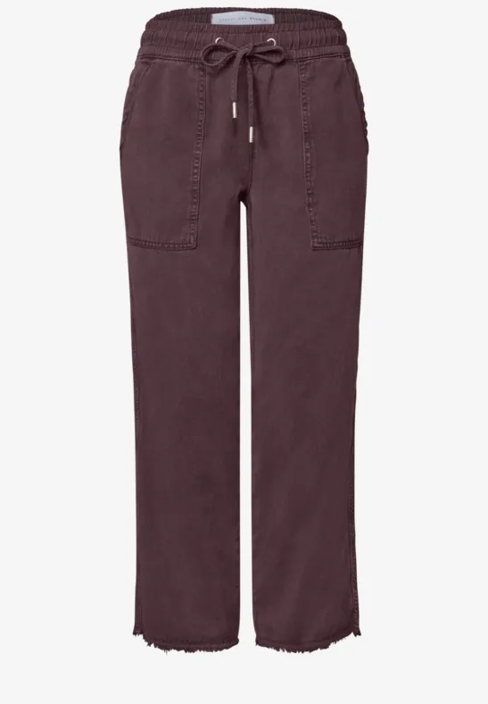 Losvallende broek met tunnelkoord, opgestikte zakken en rafelige zoom, rechte pijpen, donker aubergine kleur