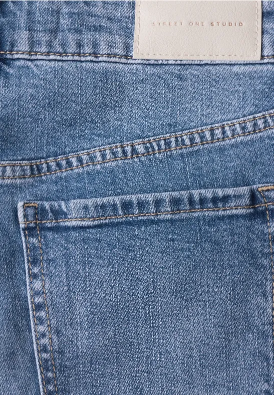 Blaue Jeans mit sichtbar aufgesetzter Gesäßtasche und Stoffetikett.