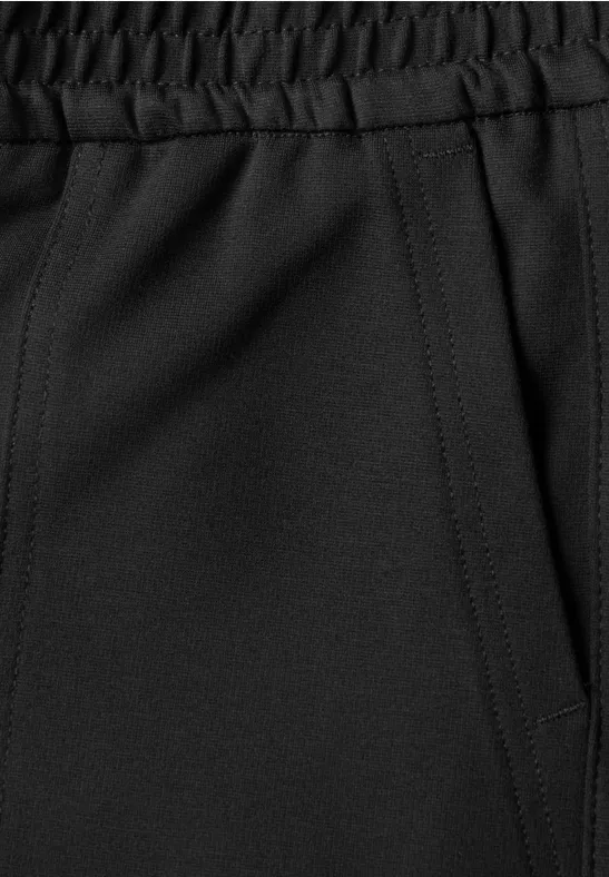 Nahaufnahme einer schwarzen Sporthose mit elastischem Bund und seitlicher Tasche