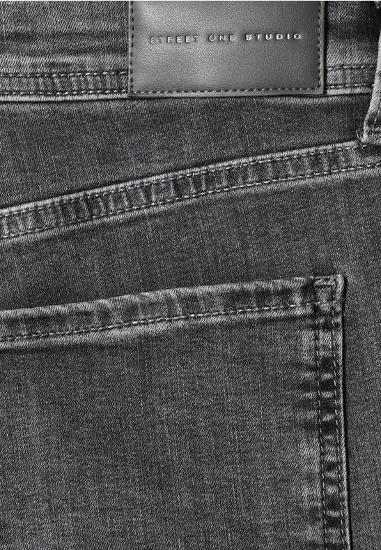 Nahaufnahme schwarzer Jeans mit Taschennaht und Lederetikett ‚SELECTED‘.
