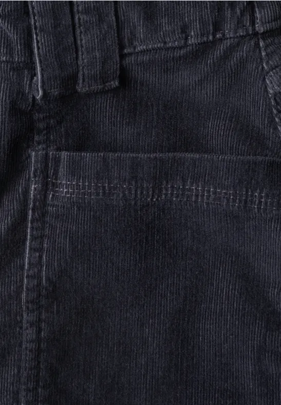 Nahaufnahme einer dunklen Cordhose mit sichtbarer Fronttasche und Gürtelschlaufen