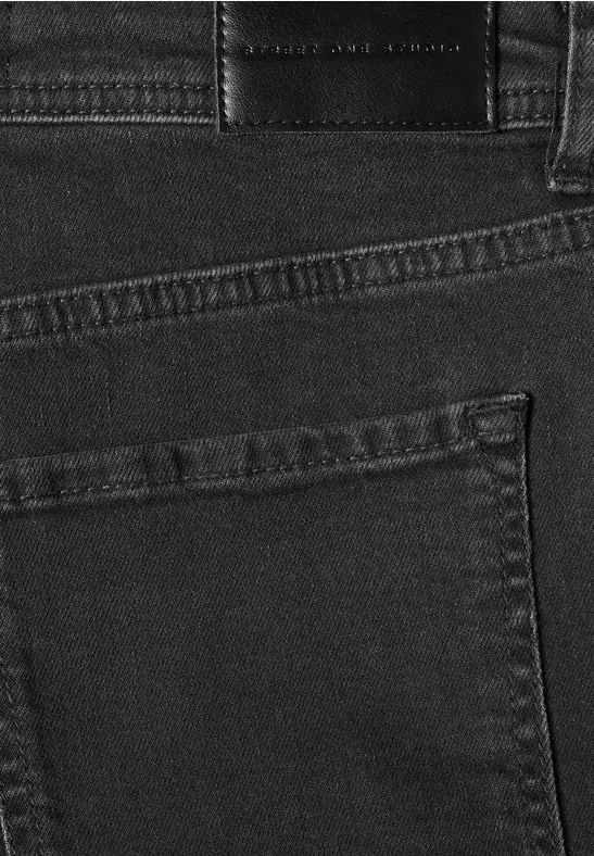 Nahaufnahme einer schwarzen Jeans von hinten mit Gesäßtasche, Gürtelschlaufen und dezentem Markenlabel