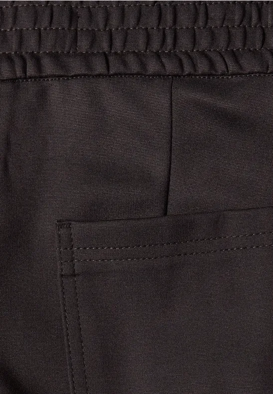 Close-up eines schwarzen Stoffhosenbunds mit elastischem Saum und aufgesetzter Tasche