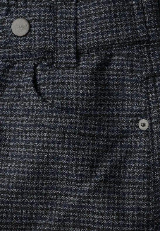 Gros plan sur un tissu de pantalon à carreaux bleu-gris, ceinture, passant et poche avant.