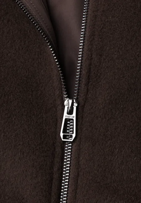 Nahaufnahme eines silbernen Reißverschlusses auf braunem Fleece-Material