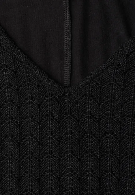 Schwarzes Oberteil mit V-Ausschnitt und fein gestricktem Zickzackmuster, Naht in der Mitte sichtbar.