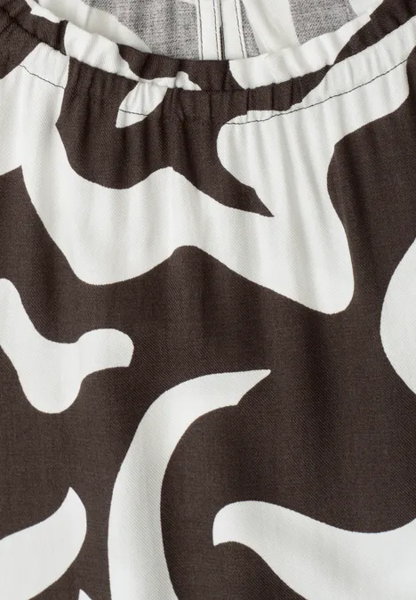 Close-up van kledingstuk met elastische taille en abstracte zwart-witte print.