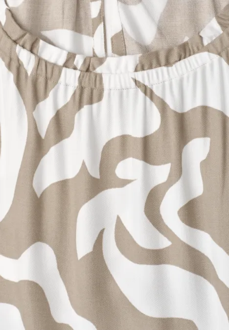 Close-up van beige-witte stof met elastische tailleband en abstract zebrapatroon.