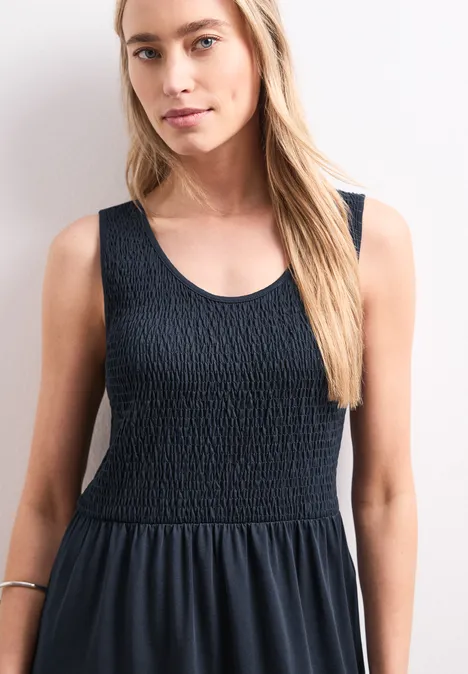 Midi-Kleid mit Smok-Oberteil deep blue Frau in ärmellosem, schwarzem Kleid mit gerafftem Oberteil und weitem Rock
