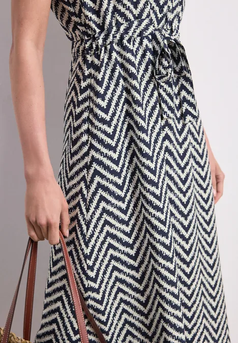 Schwarz-weißes Zickzack-Midikleid mit Taillengürtel, stylisch und elegant.