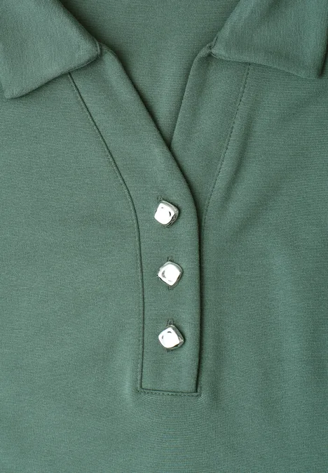 Grünes Poloshirt mit Kragen und drei eckigen weißen Knöpfen.