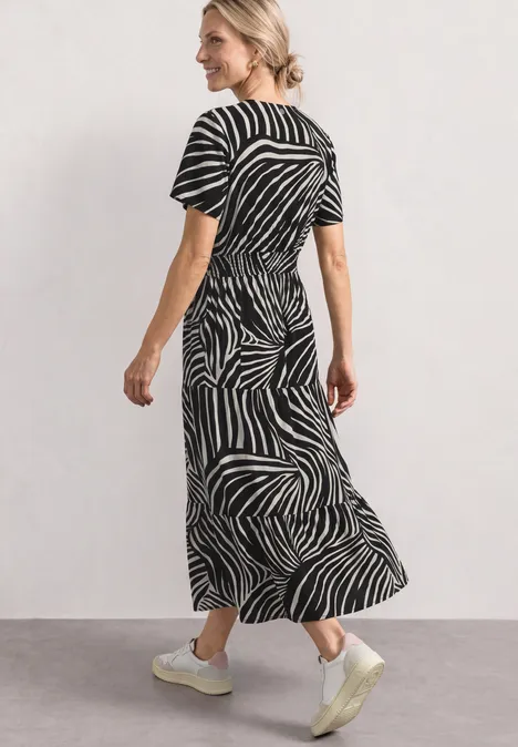 Robe midi avec imprimé et détail smocké Black Femme portant une robe midi à motif zèbre noir et blanc, manches courtes, baskets blanches.