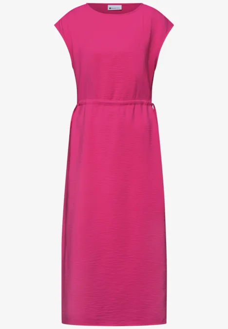 Różowa sukienka do kolan z dekoltem typu łódka i podkreśloną talią.