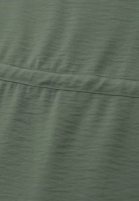 Olivegrüner Stoff mit Naht und leicht sichtbarer Struktur.