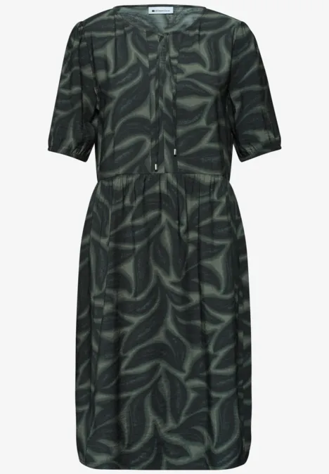 Donkergroene, knielange jurk met abstract bladpatroon en korte mouwen.
