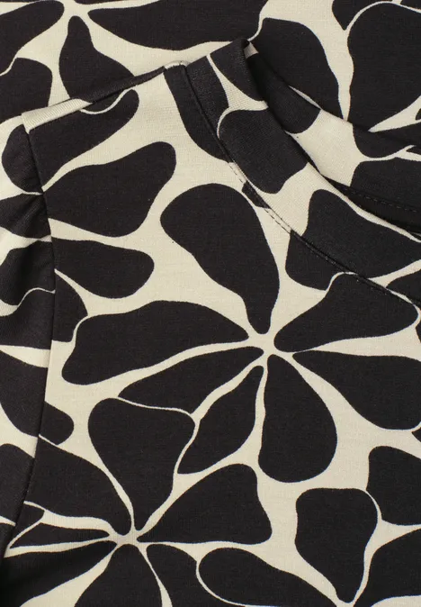 Abstract bloemmotief met zwarte, organische vormen op crèmekleurige stof