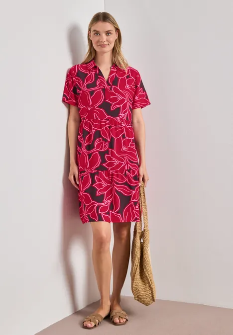 Knielanges Kleid mit Kurzarm und Print salsa red Frau in rotem Blumenkleid mit V-Ausschnitt, kurzen Ärmeln, Strohtasche und flachen Sandalen