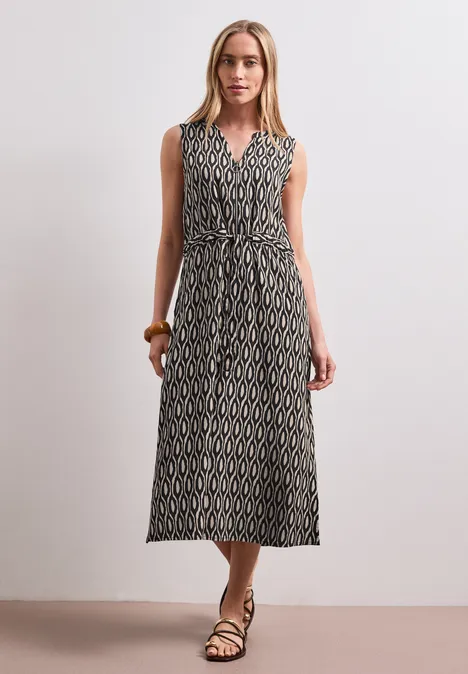 Midi-Kleid mit Split Neck und Zipper clay sand Frau in ärmellosem, gemustertem Maxikleid mit Bindegürtel und Sandalen.