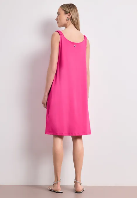 Knielanges Kleid mit gerafften Trägern magenta dream Frau in ärmellosem pinkfarbenem Kleid, Rückenansicht, mit flachen Sandalen.