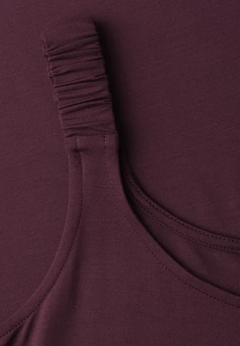 Knielanges Kleid mit gerafften Trägern rustic rouge Nahaufnahme eines ärmellosen, burgunderfarbenen Oberteils mit gerafftem Träger.