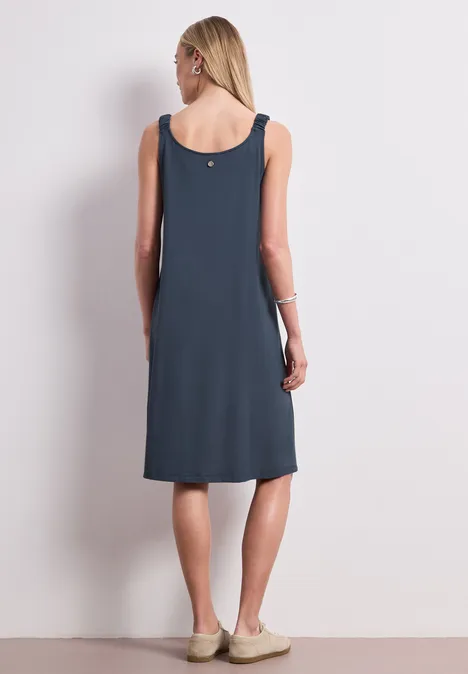 Dunkelgraues ärmelloses Midikleid an einer Frau, Rückansicht, schlichtes Design, knielang.