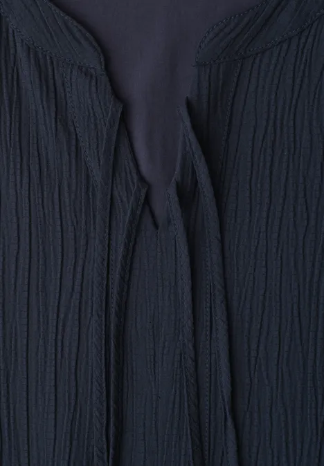 Donkerblauwe, gestructureerde gebreide cardigan met striksluiting bij de hals.