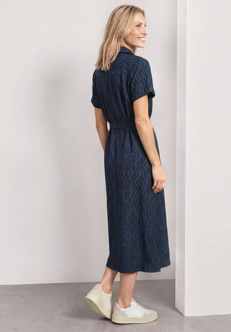Midikleid mit Bowling-Kragen darkest blue Eine Frau trägt ein knielanges, dunkelblaues Hemdkleid mit kurzen Ärmeln und weiße Sneaker.