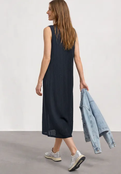 Midikleid aus Spitze mit Rundhals darkest blue Frau von hinten in schwarzem, ärmellosem Midikleid, trägt Jeansjacke, weiße Sneaker.