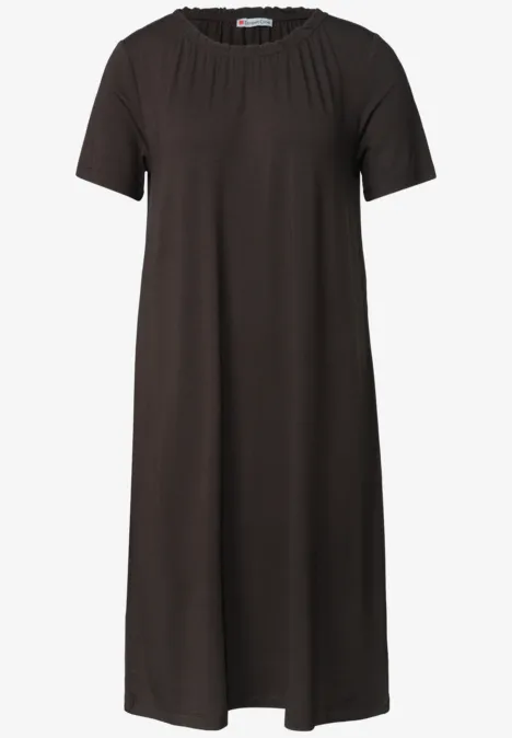 Een eenvoudig zwart T-shirtjurk tot op de knie met ronde hals en korte mouwen.