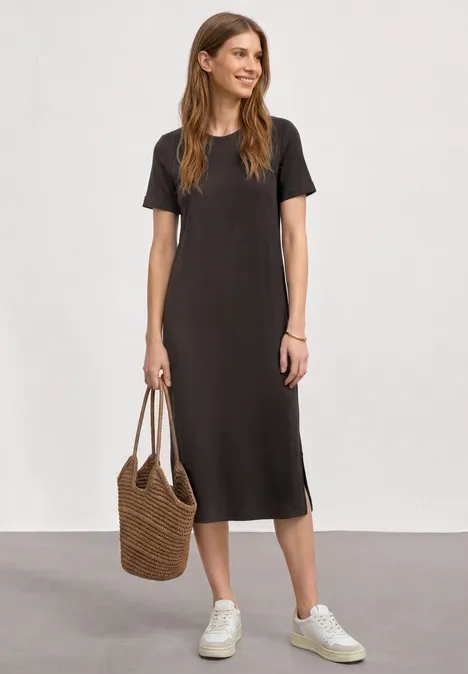 Midikleid in Rippstruktur mit Rundhals black coffee Frau in schlichtem, schwarzem Midikleid mit Kurzarm, weißen Sneakern und Korbtasche.