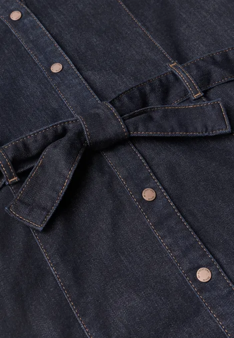 Veste/robe en jean foncé à boutons-pression argentés et ceinture taille-haute.