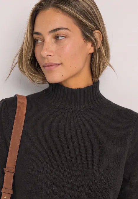 Portrait einer Frau in schwarzem Rollkragenpullover, seitlich blickend