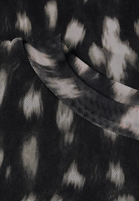 Schwarzes T-Shirt mit unregelmäßigen weißen Flecken, abstraktes Stoffmuster