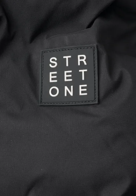 Close-up van een zwarte stof met een aangebracht label met de tekst 'STREET ONE'.