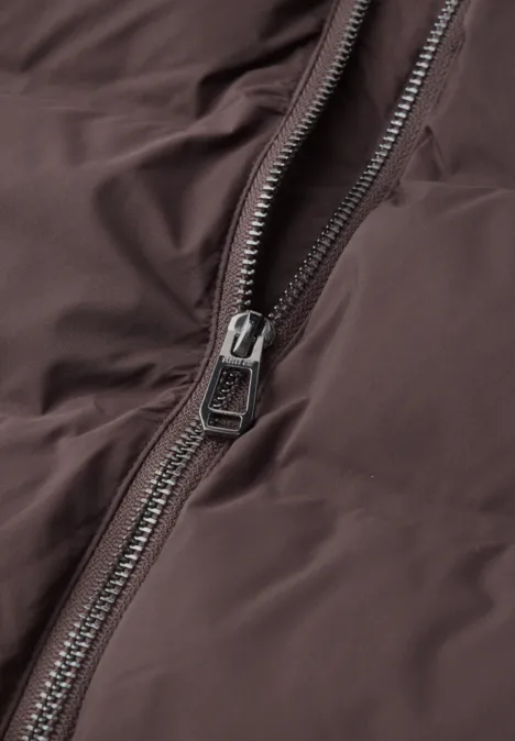 Gros plan d'une fermeture éclair sur une veste marron.