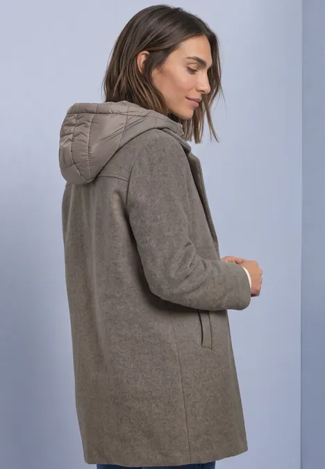 Vue latérale d’une femme portant un manteau en laine gris à capuche.