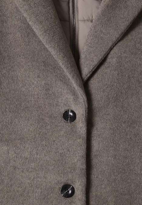 Gros plan d’un manteau gris en laine avec revers et deux boutons noirs