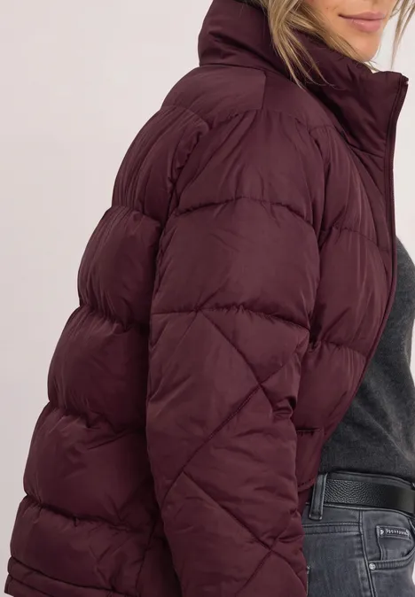 Vrouw in profiel met een bordeaux gewatteerd jack