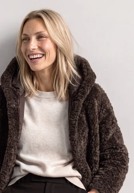 Teddymantel mit gefüttertem Inlay auburn brown Eine blondhaarige Frau, die lächelnd eine braune Teddyjacke und ein helles T-Shirt vor neutralem Hintergrund trägt.