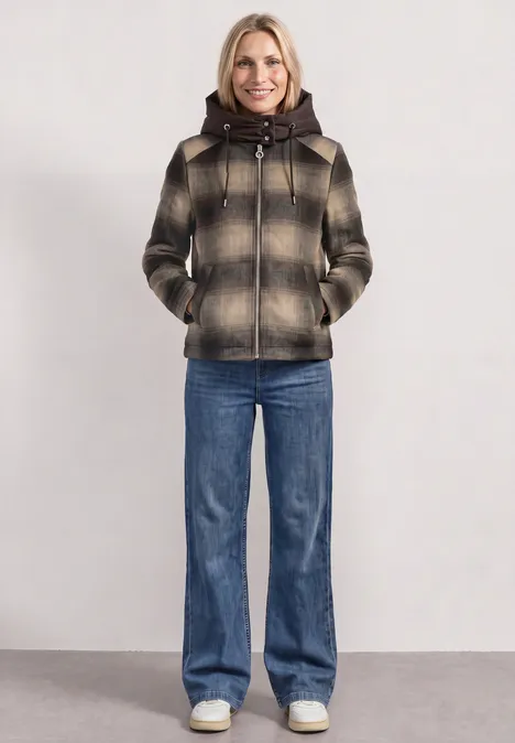 Veste contenant de la laine, avec capuche amovible auburn brown Frau in karierter, kurz geschnittener Kapuzenjacke und Schlagjeans vor neutralem Hintergrund.