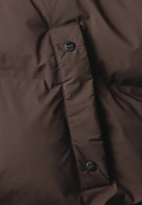 Lange Jacke mit Kapuze und Steppmuster auburn brown Nahaufnahme einer braunen Steppjacke mit Druckknöpfen.